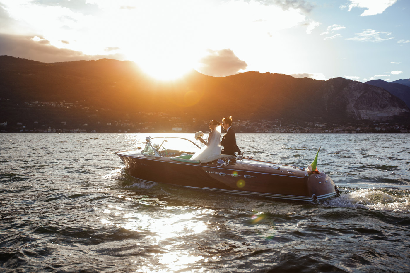 Villa Rusconi Clerici wedding photographer Lake Maggiore, bride and groom on boat at the sunset