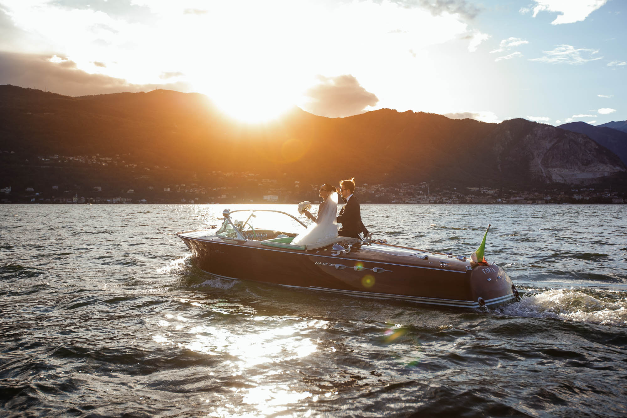 wedding photographer Italy: bride and groom on boat at Lake Maggiore during an amazing sunset